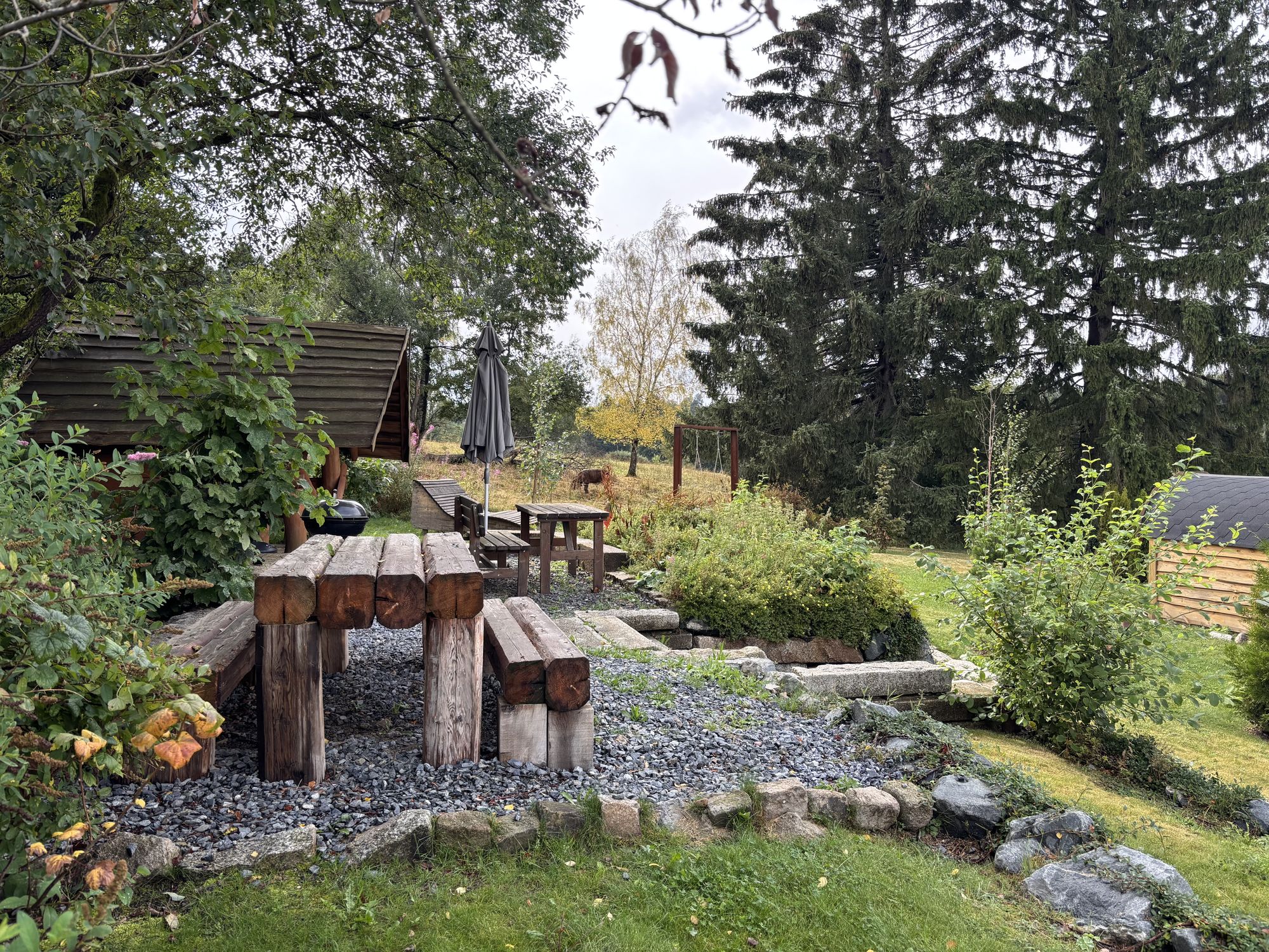 Sitzplatz mit Holzbänken im Garten