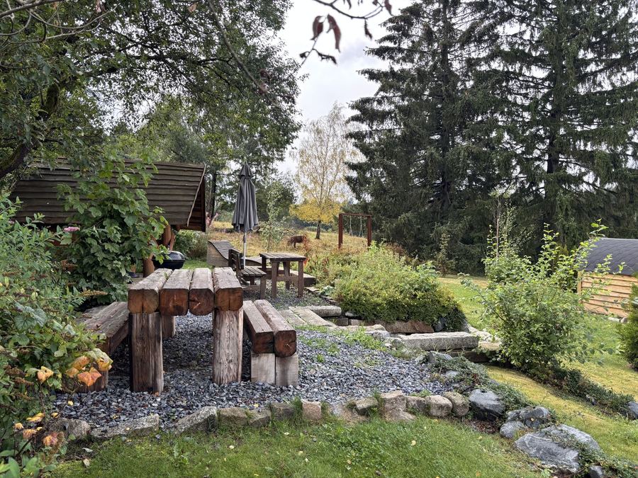 Sitzplatz mit Holzbänken im Garten